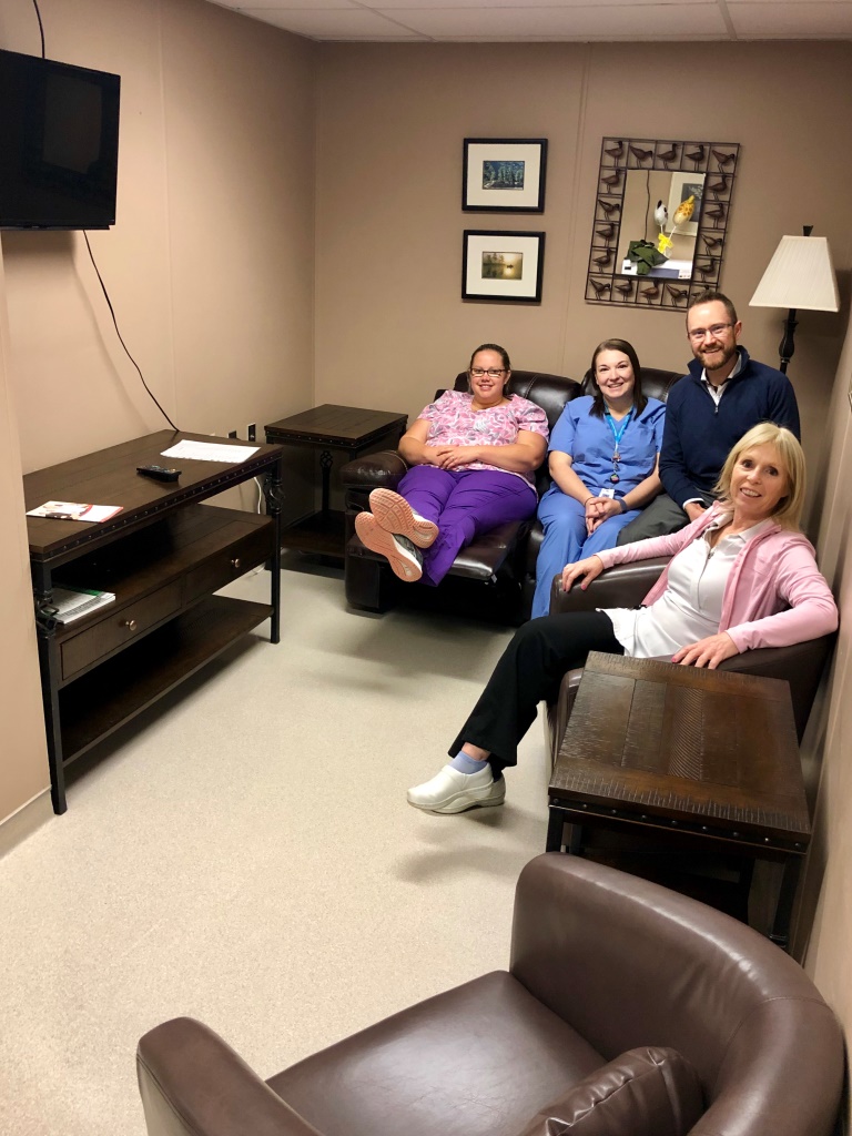 Staff sitting on donated furniture in lounge