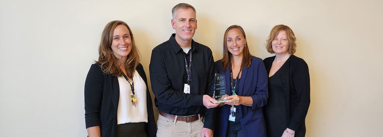 Four people holding Trillium Gift of Life Network award for role in organ and tissue donation.