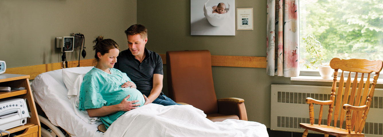 Pregnant woman with partner in a labour and delivery hospital bed