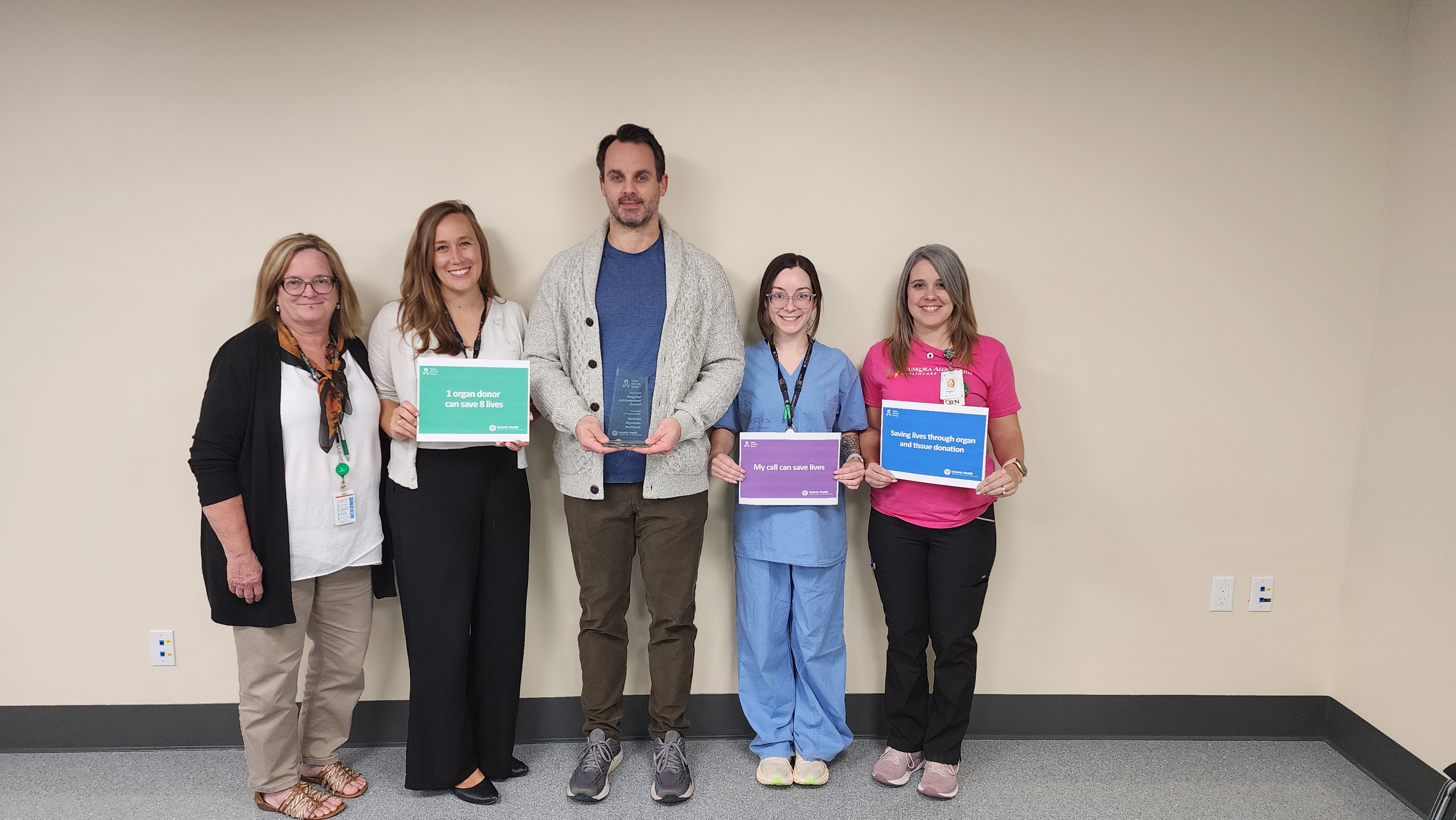 Five people standing with organ donation signs and an award from Trillium Gift of Life