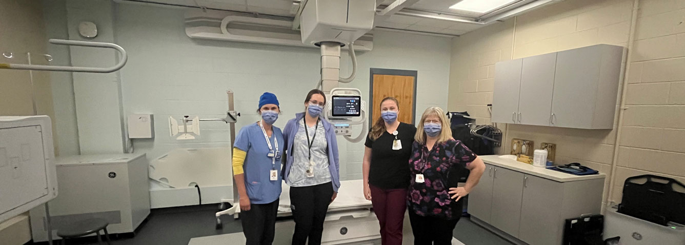 Hospital staff standing in front of a new X-ray machine in The Sprott Foundation Diagnostic Imaging Department at Huntsville District Memorial Hospital.