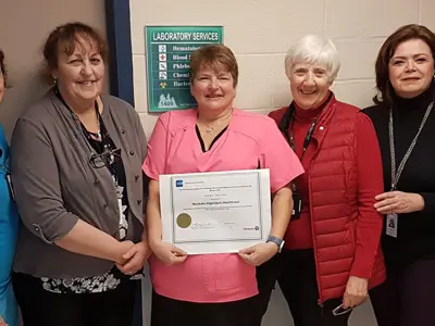 Laboratory staff holding a certificate for top performing hospital