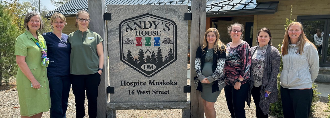 Staff from Hospice Muskoka and Muskoka Algonquin Healthcare flanking Andy's House exterior signage.