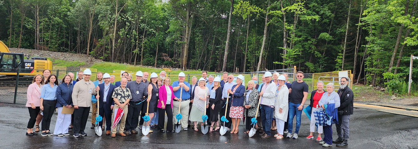 Group of people with shovels in front of MRI construction site